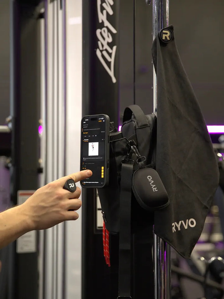 Hand reaching for the black RYVO Rig Pro bundle mounted on a gym machine