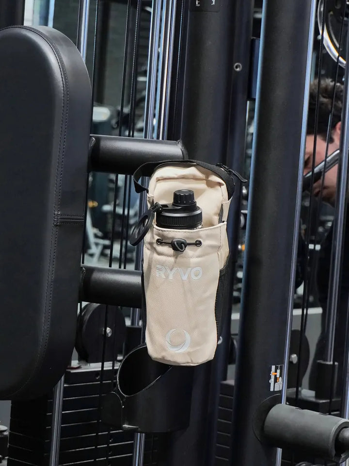 Beige RYVO Rig magnetic gym bag attached to a cable machine in the gym